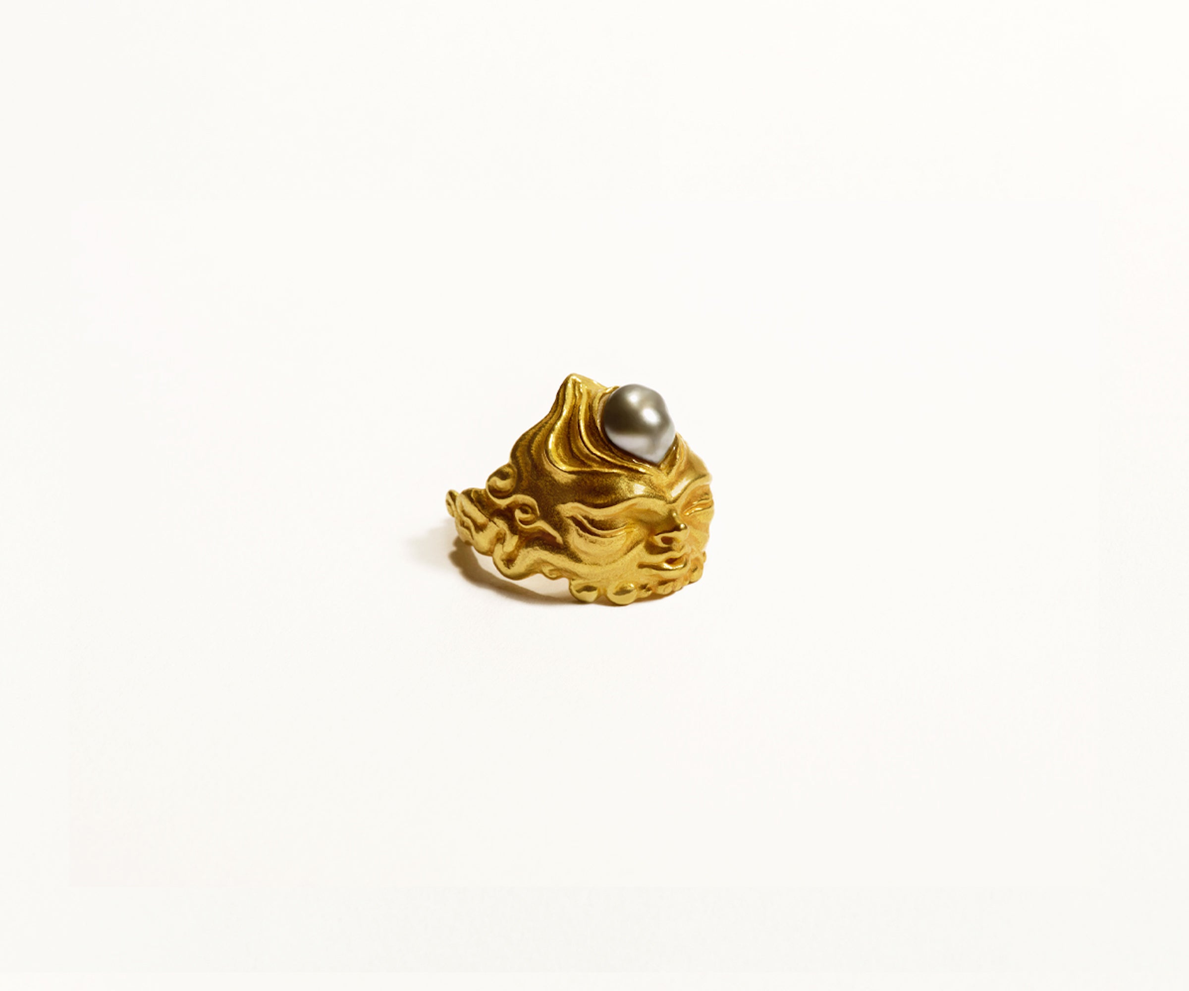 An 18K yellow gold ring shaped like a gnome, with a black Tahitian pearl emerging from its forehead.