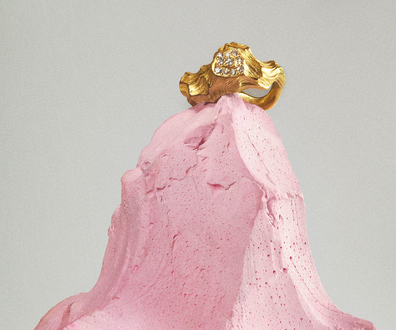 An 18K yellow gold ring shaped like waves in water, with 10 small diamonds set along the front.