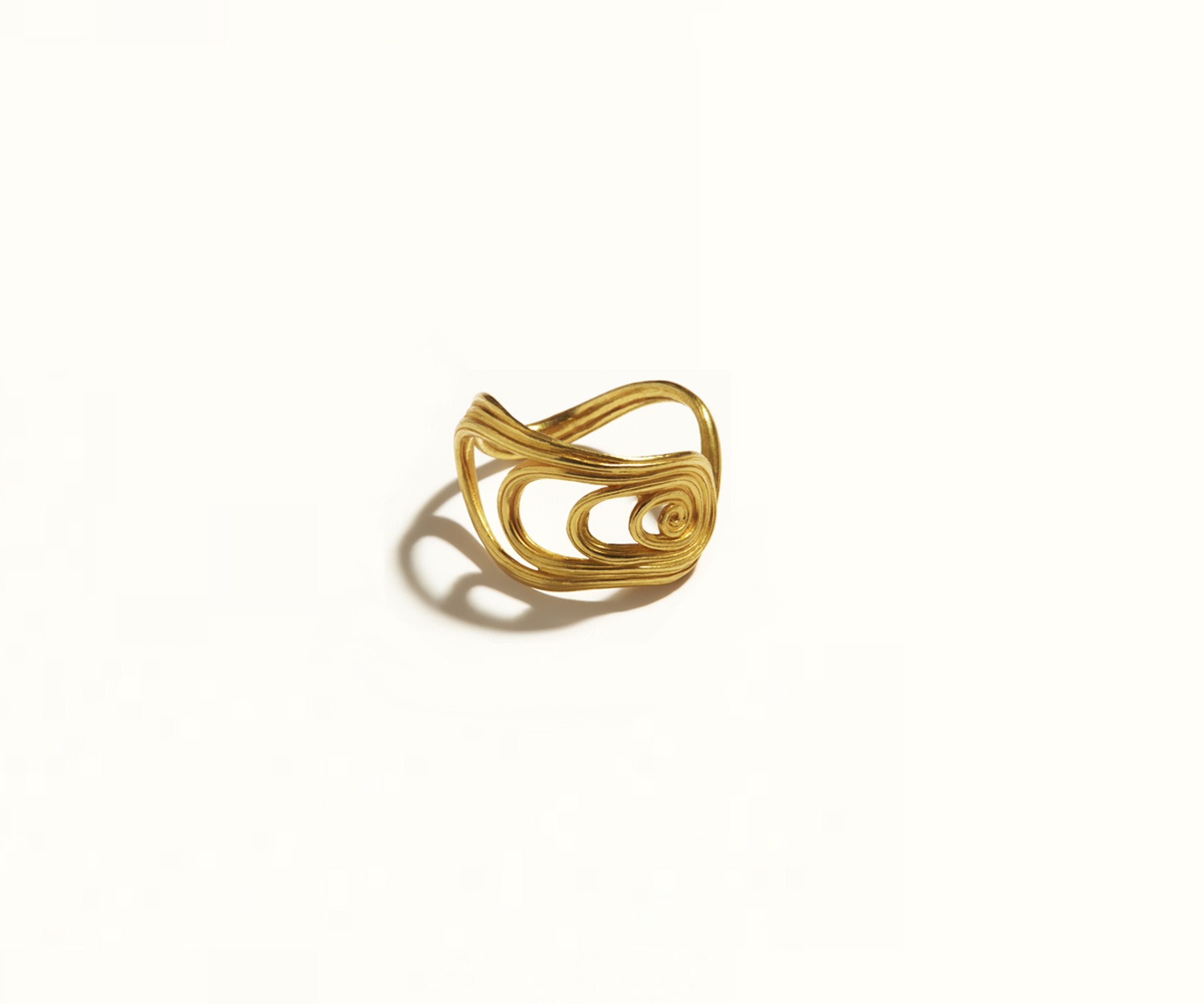 An 18K yellow gold ring designed to resemble a large fan. Showed on a white background.