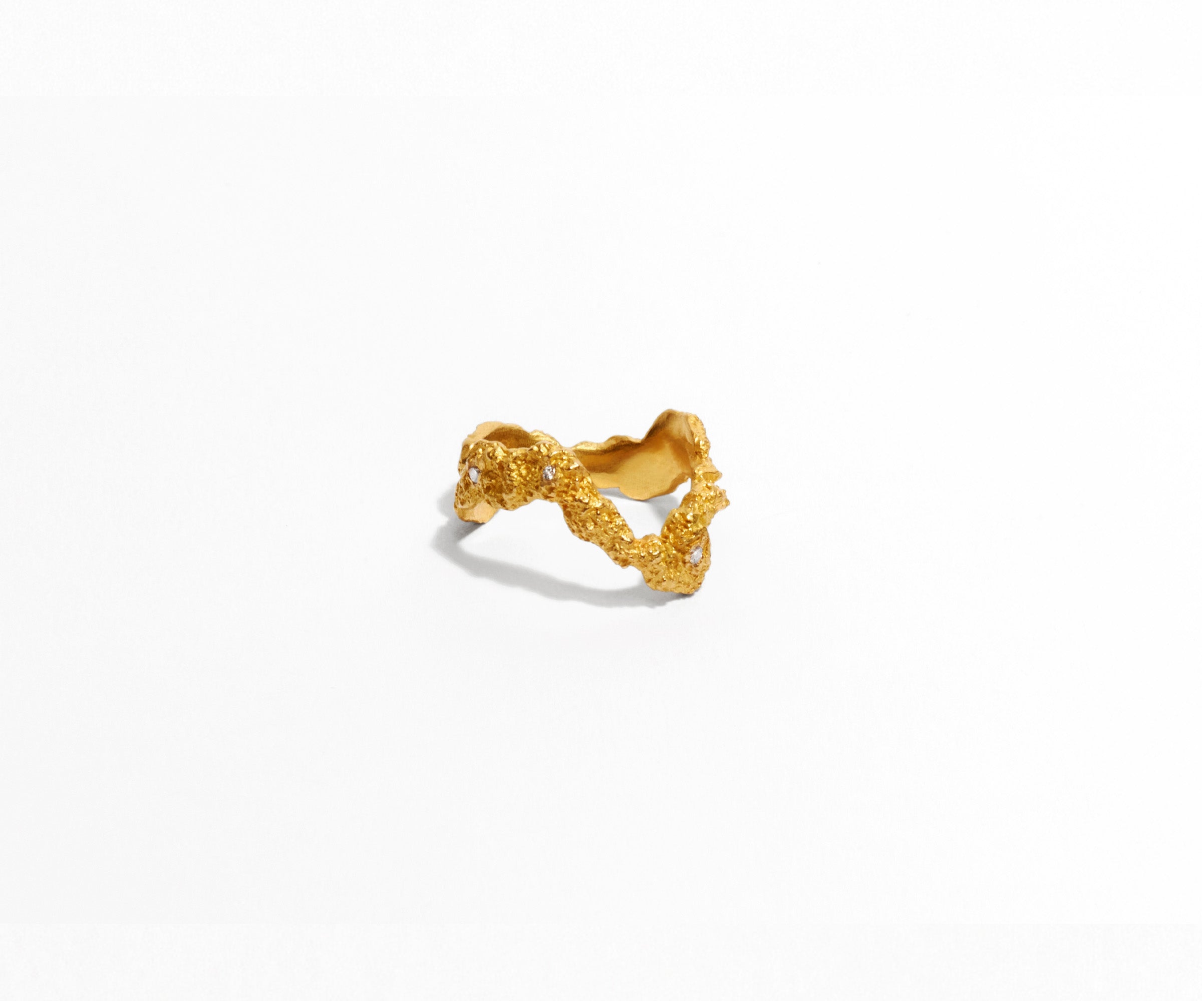 A slim 18K yellow gold ring with 7 small diamonds, shaped organically, inspired by the universe.
