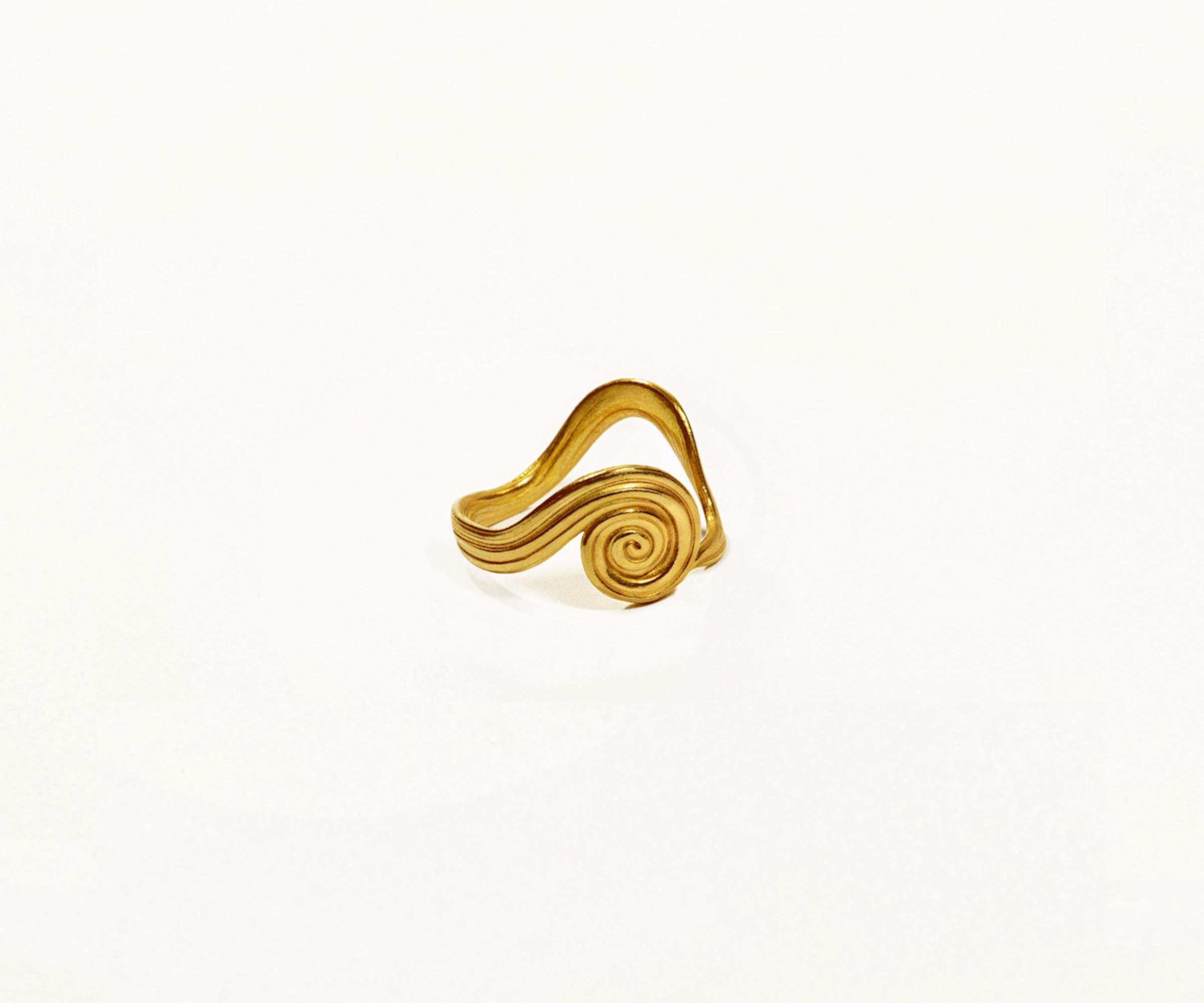 A spiral ring crafted from 18K yellow gold, featuring an organic shape, displayed on a white background.