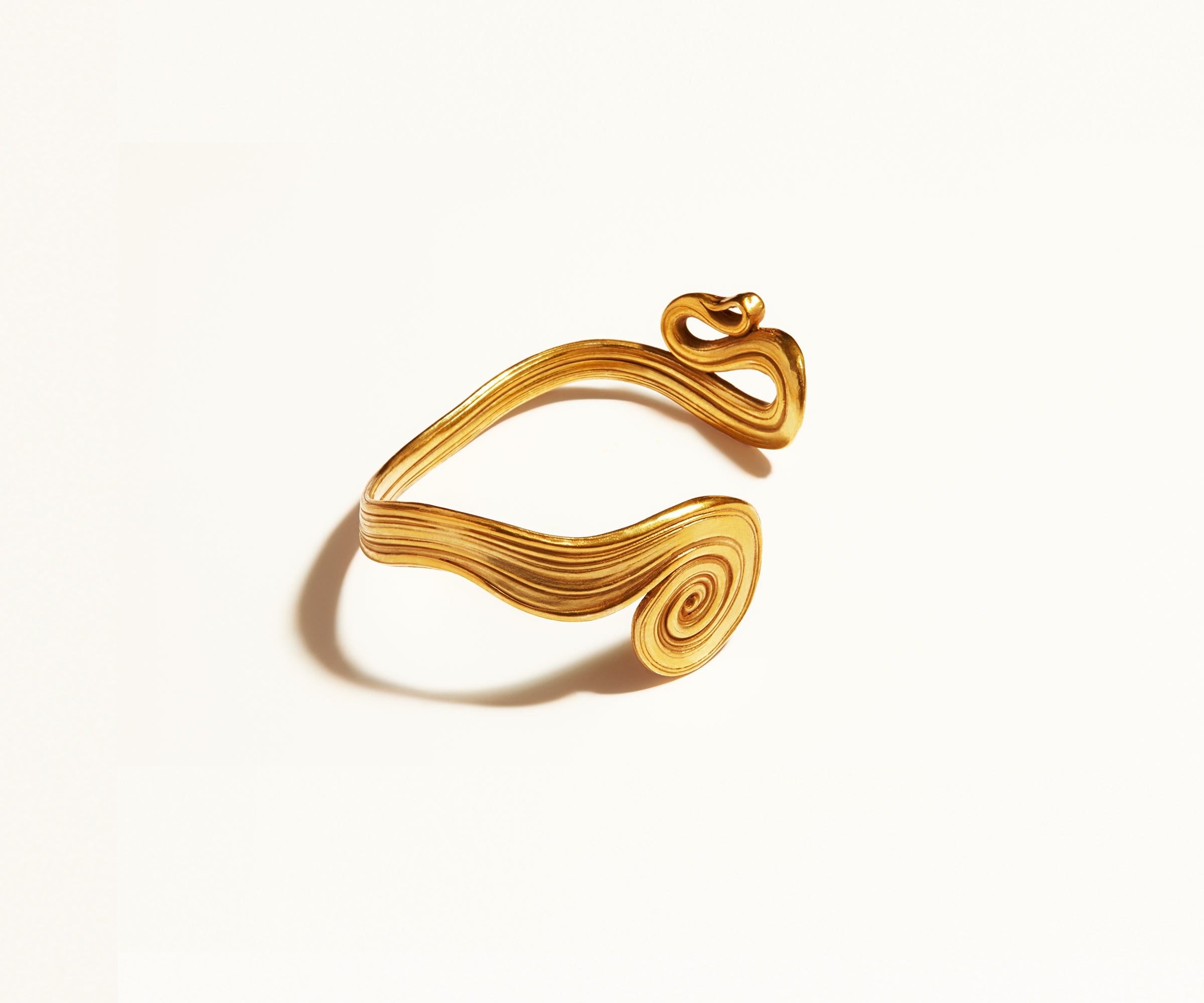 An 18K gold bracelet titled ‘Spiral Bracelet No. 10’ from the early 1970s made in Denmark by fine jewellery designer Arje Griegst. The cuff bracelet resembles an abstract, wavy piece of Ancient Roman jewellery: a wide cuff with ribbed lines running through the gold that forms a coil spiral at either end.